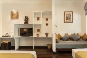 a living room with a couch and a television at Pavillon d'Orient Boutique Hotel in Siem Reap