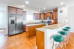 a kitchen with a stainless steel refrigerator and bar stools at Seaside Village --- #3 in Ocean City