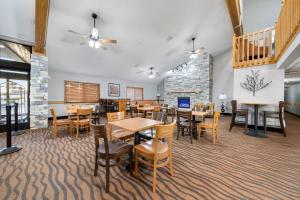 a dining room with tables and chairs and a staircase at AmericInn by Wyndham Ames in Ames