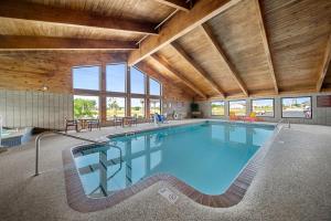 a large swimming pool in a building with wooden ceilings at AmericInn by Wyndham Ames in Ames
