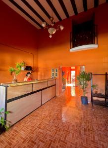 a kitchen with orange walls and a wooden floor at Alena Hostal in Valladolid