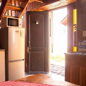 cocina con nevera y puerta con microondas en Cabañas Zu Hause, en Valdivia
