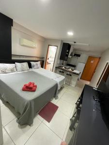 1 dormitorio con 1 cama con 2 toallas rojas en Flat Luxo Completo em Boa Viagem junto ao Shopping, en Recife