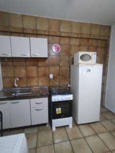 uma pequena cozinha com um fogão e um frigorífico em Apto Centro Floripa 03 em Florianópolis