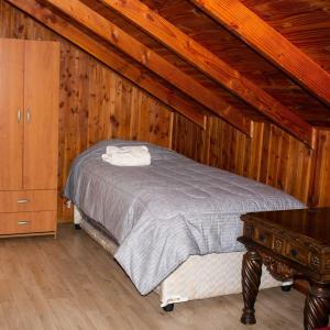 1 dormitorio con cama y techo de madera en Cabañas Zu Hause, en Valdivia