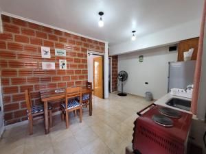 een keuken met een tafel en een bakstenen muur bij GaVal Apart in Posadas