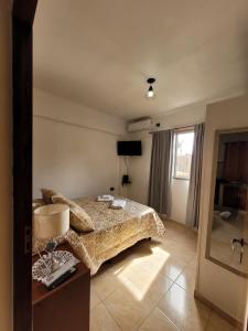 een slaapkamer met een bed, een tafel en een raam bij GaVal Apart in Posadas