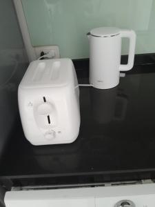 a white toaster sitting on a black counter top at Arisara place in Koh Samui