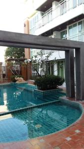 a swimming pool with blue water in front of a building at Arisara place in Koh Samui 