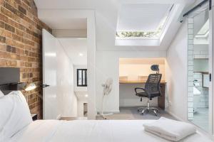 - une chambre avec un lit, un bureau et une chaise dans l'établissement A Charming Sunny Terrace in the Heart of Newtown, à Sydney