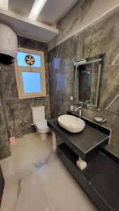a bathroom with a sink and a toilet and a window at مارسيليا بيتش 4 in Sīdī ‘Abd ar Raḩmān