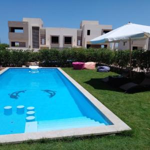 a swimming pool in the yard of a house at مارسيليا بيتش 4 in Sīdī ‘Abd ar Raḩmān
