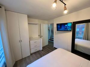 1 dormitorio con 1 cama y TV en la pared en CUADRUPLEX Con TERRAZA, en Lima