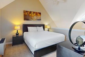 a bedroom with a white bed and a mirror at Condo 413 at North Creek Resort by Vacasa in Blue Mountains +29 photos