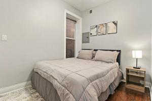 um quarto branco com uma cama e uma janela em Live the Dream in Wrigleyville's 3BR Gem em Chicago