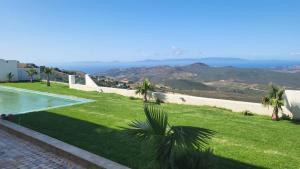a view of a lawn with a swimming pool at Villa avec vue panoramique in Tangier