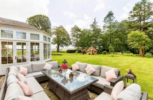 a patio with a couch and a table and a yard at Private room & bathroom in Manor House in Maybole