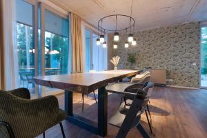 a dining room with a wooden table and chairs at Marina Maisonette Seeblick mit Pool und Sauna in Bad Saarow