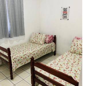 Cette chambre comprend deux lits, un canapé et une fenêtre. dans l'établissement Mãezinha do céu, à Aparecida