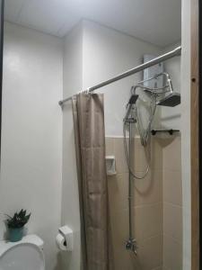 a bathroom with a shower with a shower curtain at 2BR SMDC Bloom Residences Near NAIA Wi-fi +Netflix in Manila