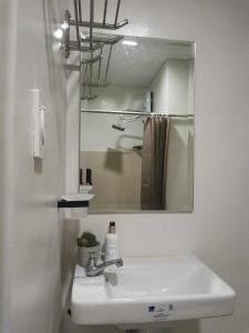 a white bathroom with a sink and a mirror at 2BR SMDC Bloom Residences Near NAIA Wi-fi +Netflix in Manila