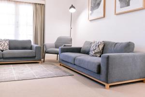 a living room with a couch and two chairs at Wagga RSL Club Motel in Wagga Wagga