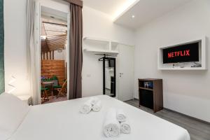 a hotel room with a bed and a tv at Spagna Boutique Suites in Rome