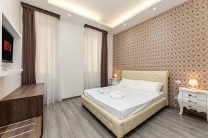 a bedroom with a large bed and a television at Spagna Boutique Suites in Rome +37 photos