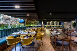 a restaurant with wooden tables and yellow chairs at Hotel Vilar América in Bogotá +54 photos
