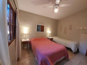 ein Zimmer mit zwei Betten und einem Fenster und zwei Lampen in der Unterkunft Hermosa casa frente al rio icho cruz 10 personas in Villa Icho Cruz + 42 Fotos