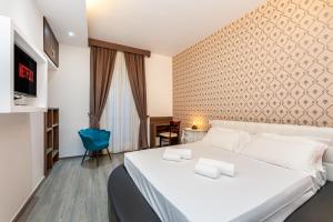 a bedroom with a white bed and a blue chair at Spagna Boutique Suites in Rome
