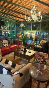 una sala de estar con sofás, mesas y una lámpara de araña. en Pousada Vilagio Chapada en Chapada dos Guimarães