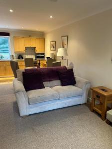 a living room with a white couch and a kitchen at Fernhill Retreat in Charmouth