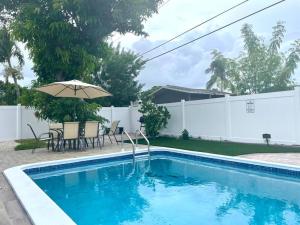 - Piscina con sombrilla, mesa y sillas en Mango’s House Close to Beach…Pool, Table Pool en Pompano Beach