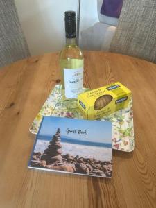 una bottiglia di vino e un libro su un tavolo di Fernhill Retreat a Charmouth