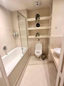 y baño con bañera, aseo y lavamanos. en NEW Spacious One Bed Apartment Near Canary Wharf, en Londres