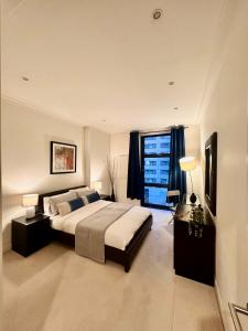 a large bedroom with a large bed and a window at NEW Spacious One Bed Apartment Near Canary Wharf in London