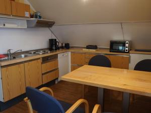 a small kitchen with a table and a microwave at Picturesque Apartment in Neu Lüdershagen with Terrace & Garden in Neu Lüdershagen