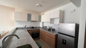 a kitchen with white cabinets and a refrigerator at Apartament Social Tree 907 in Lima +17 photos