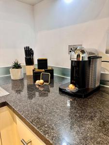 a kitchen counter with a coffee maker on a counter top at NEW Spacious One Bed Apartment Near Canary Wharf in London