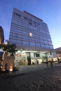 un edificio alto con gente caminando delante de él en Panorama, en San Luis Potosí