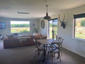 ein Wohnzimmer mit einem Tisch und einem Sofa in der Unterkunft Ben Ohau Villa in Twizel