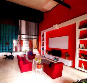 a living room with red walls and a flat screen tv at Pacific Harbor Eco Villa and Shark Dive Accomodations in Pacific Harbour