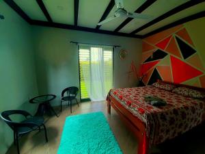 1 dormitorio con 1 cama, mesa y sillas en Pacific Harbor Eco Villa and Shark Dive Accomodations, en Pacific Harbour