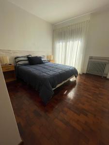 um quarto com uma cama e piso em madeira em B&G APART BELGRANO em Río Cuarto