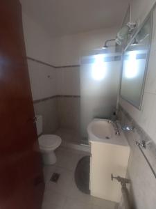 uma casa de banho com um WC, um lavatório e um espelho. em B&G APART BELGRANO em Río Cuarto