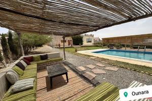 un patio de madera con banco y piscina en Villa Dar Ma Ma (Ounagha), en Essaouira