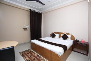 a bedroom with a bed and a desk and a table at OYO 10216 Hotel UK Retreat in Bhowāli
