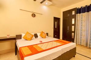 een slaapkamer met een bed met oranje en gele kussens bij OYO 3594 Kamla Nagar in New Delhi