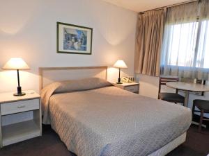 a hotel room with a bed and a table at Hotel Tres Cruces in Montevideo